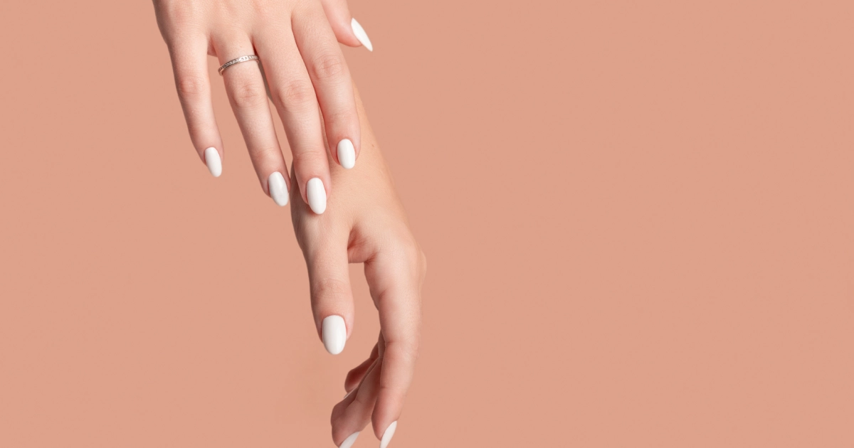 Manicured hands with white nail polish at Nail Treatments in Flower Mound, TX.
